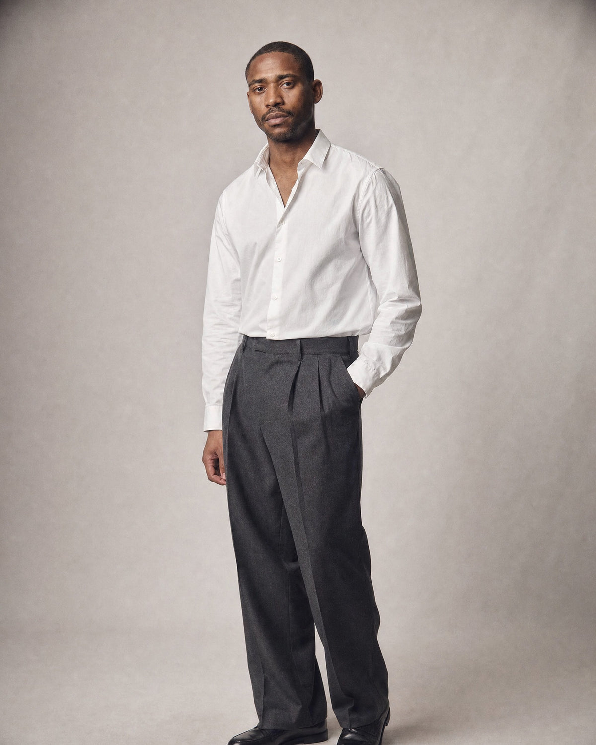 Men's Herringbone Pleated Trousers worn, three-quarter view | Belmorne